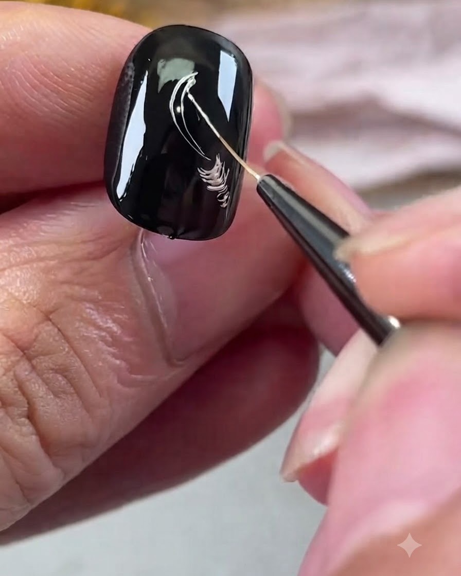 Ein feiner Liner-Pinsel zeichnet silberne metallicfarbene Blütenblattumrisse auf einen schwarzen Gel-Nagel.