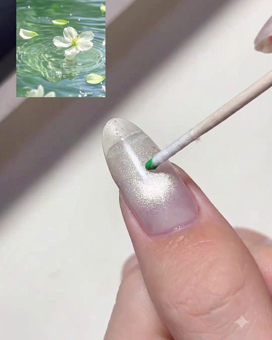 Ein Rosenholzstäbchen platziert einen Tropfen transparentes grünes Tint-Gel auf einen schimmernden Nagel.