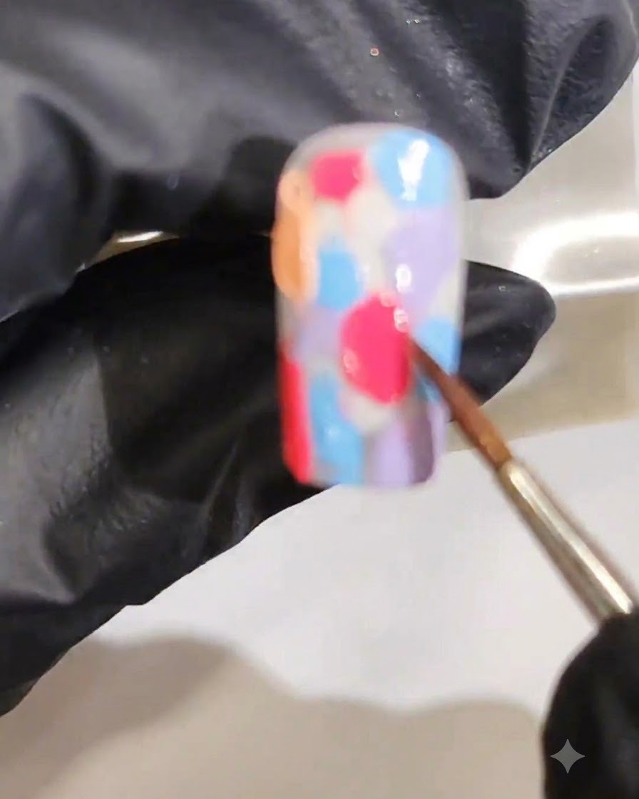 Ein feiner Pinsel verblendet mehrere feuchte Gel-Farben zu einem glatten marmorierten Aquarell-Verlauf.
