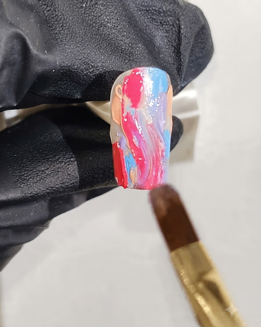 Ein feiner Pinsel trägt verstreute Silberglitter-Flocken über ein feuchtes Marmor-Nageldesign auf.