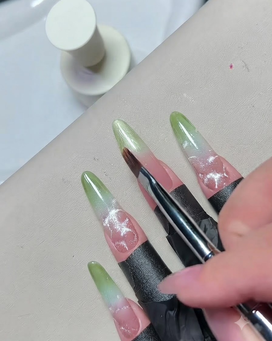 Nahaufnahme eines feinen Pinsels, der den Rand des grünen Gels verblendet, um einen nahtlosen Ombre-Effekt zu erzeugen.