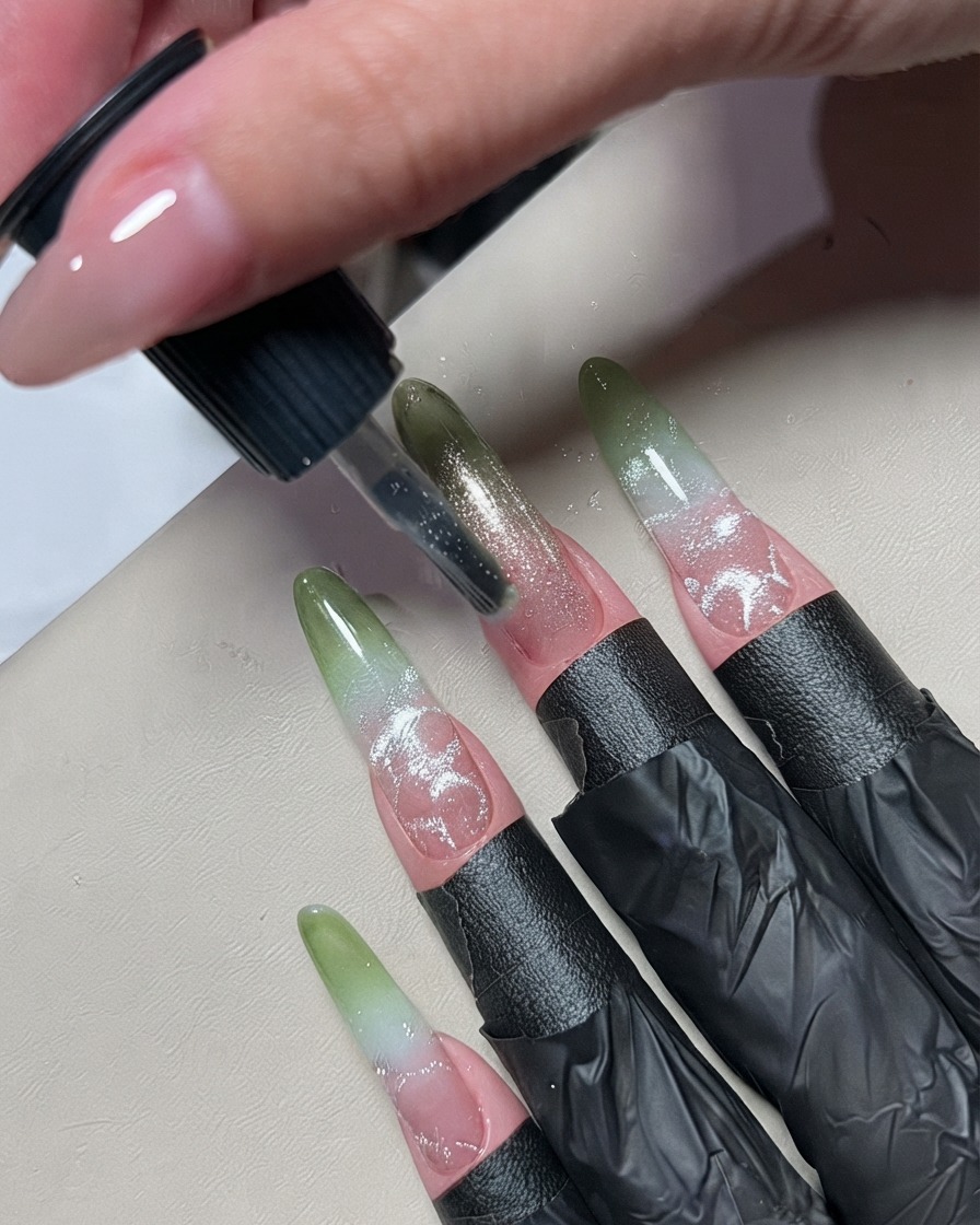 Ein kleiner Nagelkunstpinsel trägt eine dünne Linie silbernes Metallic-Gel in die Mitte eines Ombre-Nagels auf.