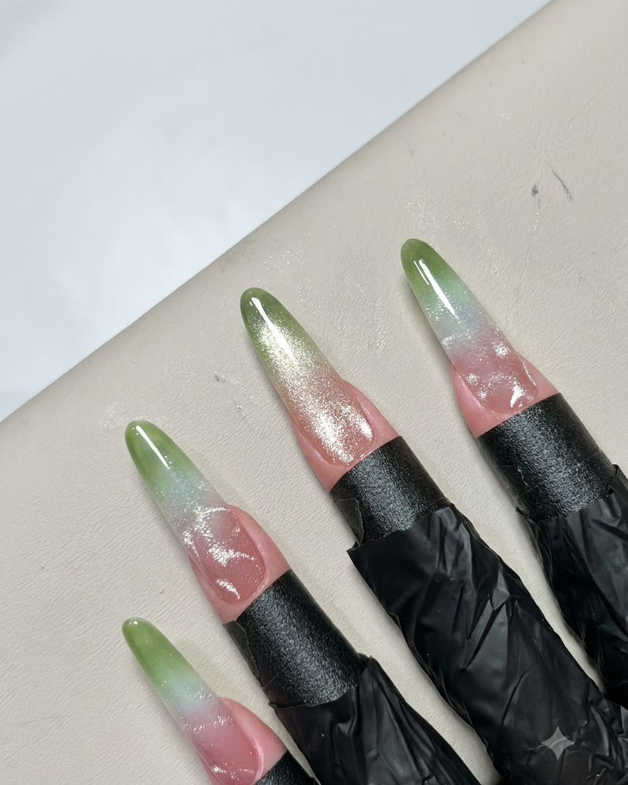 Feine Pinzetten platzieren kleine metallische Perlenaccessoires auf einem fertigen Nail-Art-Muster.