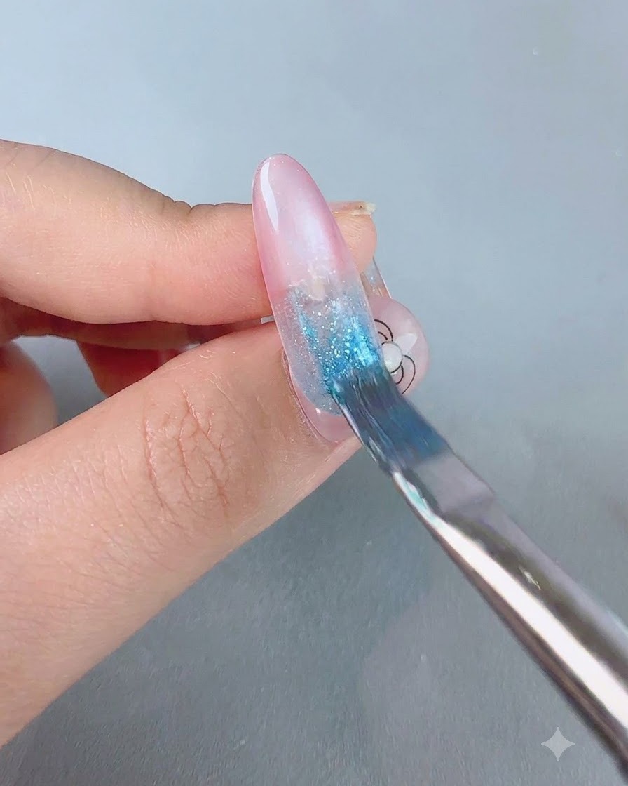 Ein weicher Farbverlaufspinsel federt blauen Gel-Lack nach unten über eine rosa Nagelbasis.