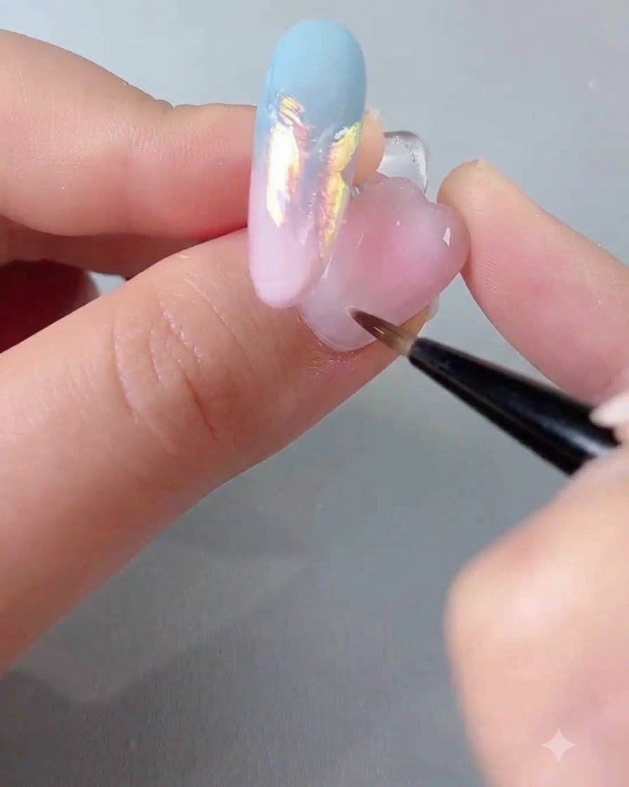 Ein Nagelackpinsel trägt eine klare Versiegelungsgelschicht über einem verzierten Nagel auf.