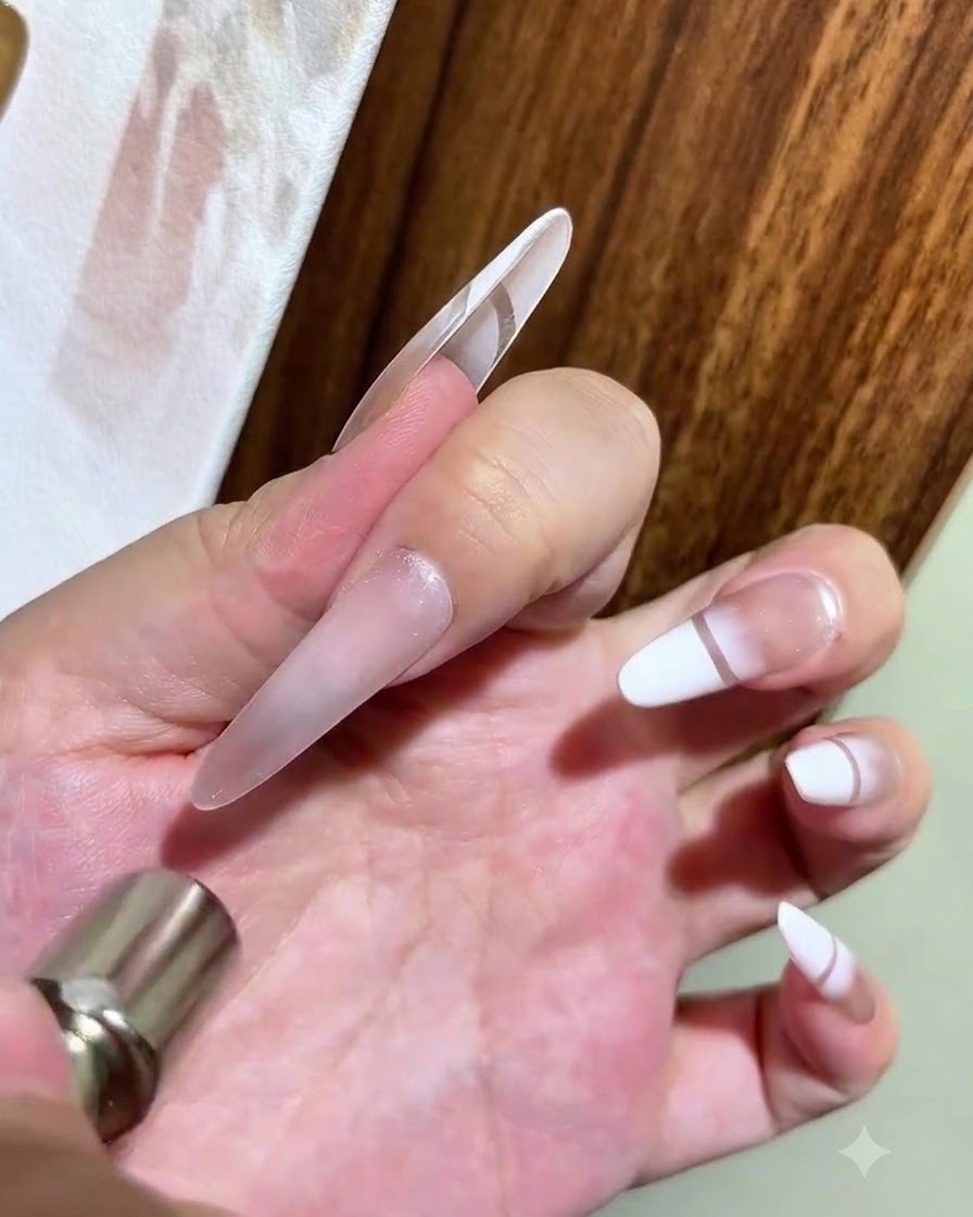 Eine Hand hält einen zylindrischen Magneten knapp über einen glänzenden Cat-Eye-Gel-Nagel, um einen leuchtenden Glasperlen-Effekt zu formen.