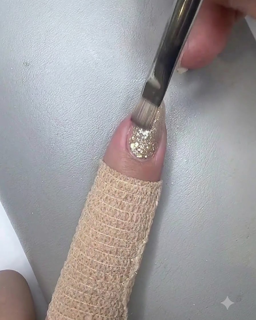 Ein flacher Pinsel trägt eine schimmernde Schicht Cat-Eye-Gel über den gestalteten Nagel auf.